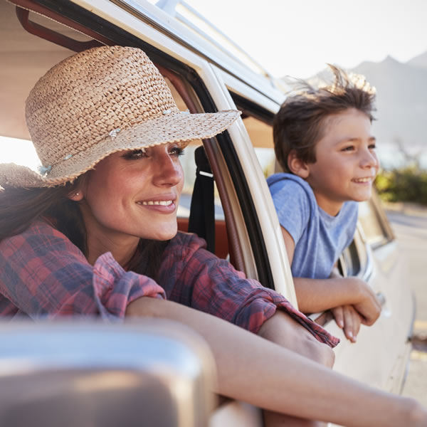 Mother and son leaning out car window